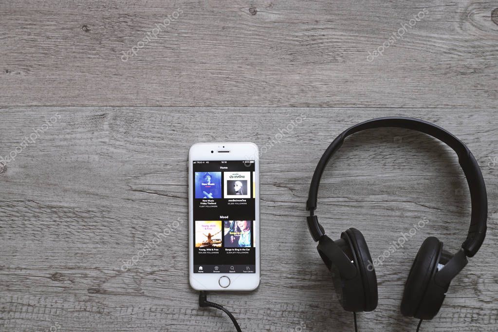 Bangkok, Thailand - April 28, 2018: Flat lay of headphone and smart phone with Spotify app on screen. Spotify is one of popular digital music providers. Image with copy space.