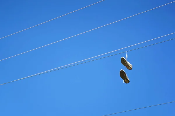 Staré Boty Sneaker Visí Elektrický Kabel Proti Modré Obloze — Stock fotografie