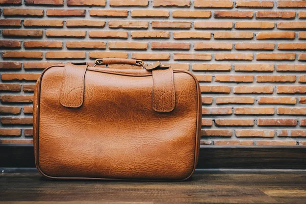 Old vintage leather luggage bag style with brick wall background