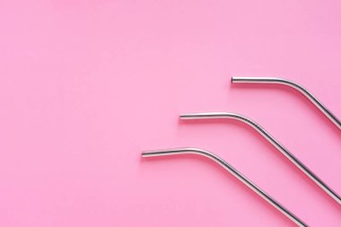 Parlak pembe arka plan, sürdürülebilir yaşam tarzı ve sıfır atık konsepti üzerinde yeniden kullanılabilir paslanmaz çelik pipetdüz yatıyordu