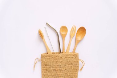 beyaz arka plan, çevre dostu ve sıfır atık kavramı üzerinde doğal çuval çanta sürdürülebilir ahşap kaşık ve paslanmaz saman 