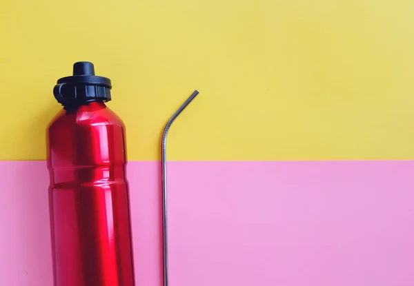 明るいピンクと黄色の背景 持続可能な製品のライフスタイルとゼロ廃棄物の概念上の飲み物のための金属ステンレスストローと再利用可能なボトルのフラットレイ — ストック写真
