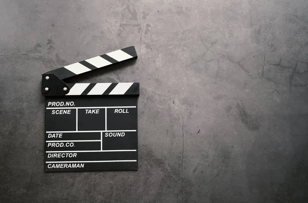 Empty clapperboard in flat lay style on dark stone background, entertainment and cinema industry concept