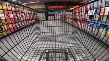 Büyük süpermarketin koridorları ve bölümleri arasında alışveriş arabasının zaman aşımı 