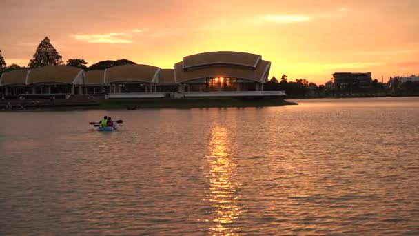 橙色日落时人们在独木舟湖中漂流 — 图库视频影像