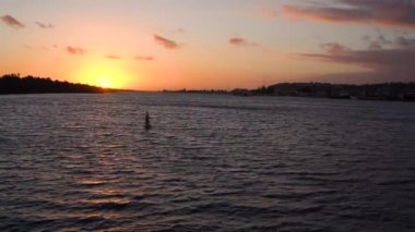 Parlak turuncu günbatımında dalgalı göl yüzeyinin resimsel görüntüsü 