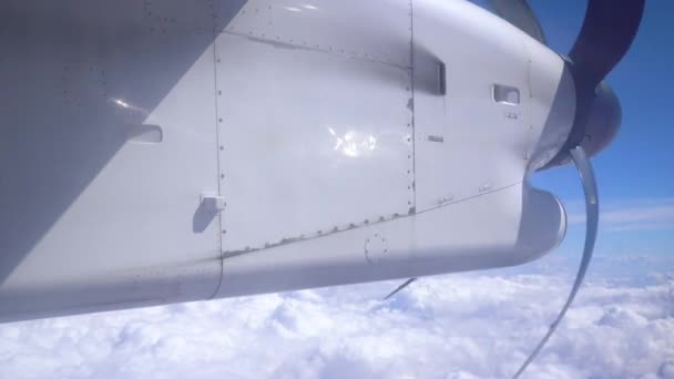 空の白い雲の間で飛行中に回転する飛行機のプロペラ — ストック動画