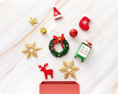 Beyaz mermer arka plan, bayram ve kutlama konsepti üzerine hediye kutusuyla süsleme için düz bir Noel süsü.