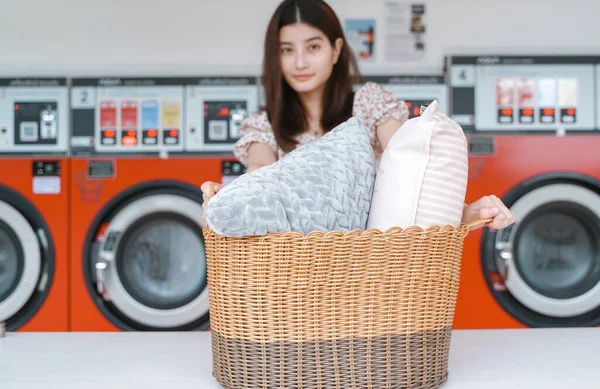 Young Millennial Asian Woman Showing Basket Clothes Pillow Automatic Laundromat — Stock Photo, Image