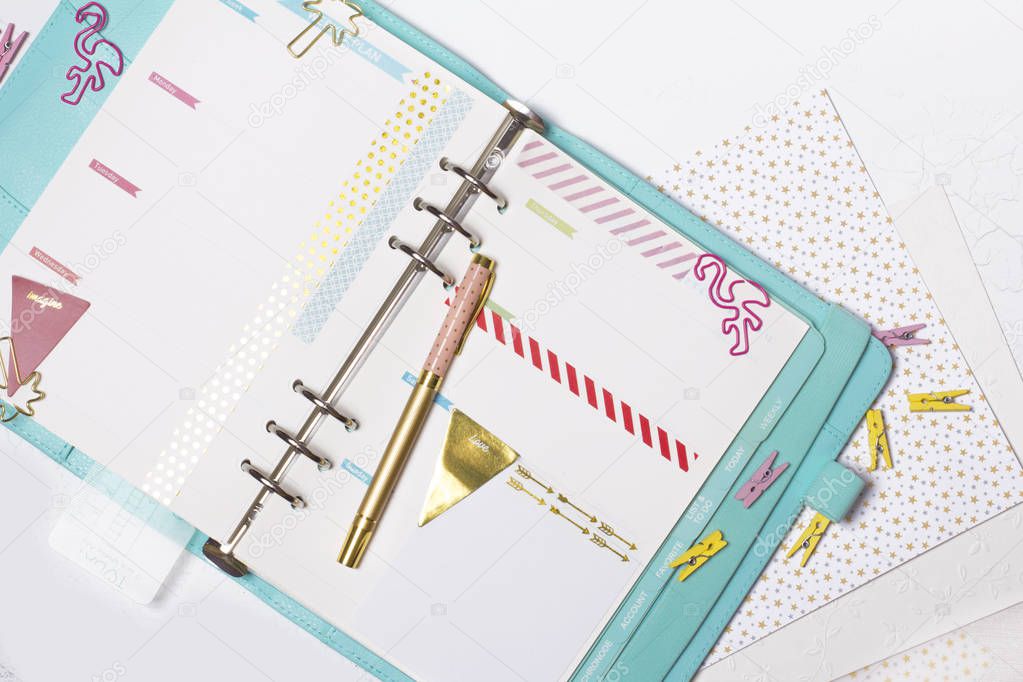 Feminine stationery: colorful paper binder clips palm and flamingo shape on white table background with washi tape. Flat lay style