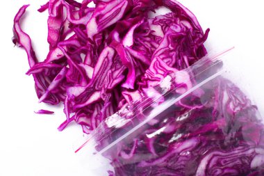 Beyaz arka plan üzerinde izole donmuş kırmızı lahana dilimleri plastik torba. Sebze koruma