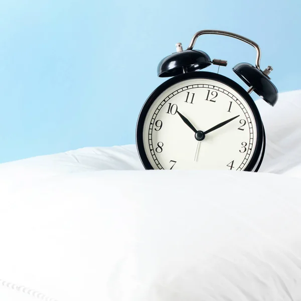 Reloj despertador en las almohadas. Concepto publicitario, espacio de copia — Foto de Stock