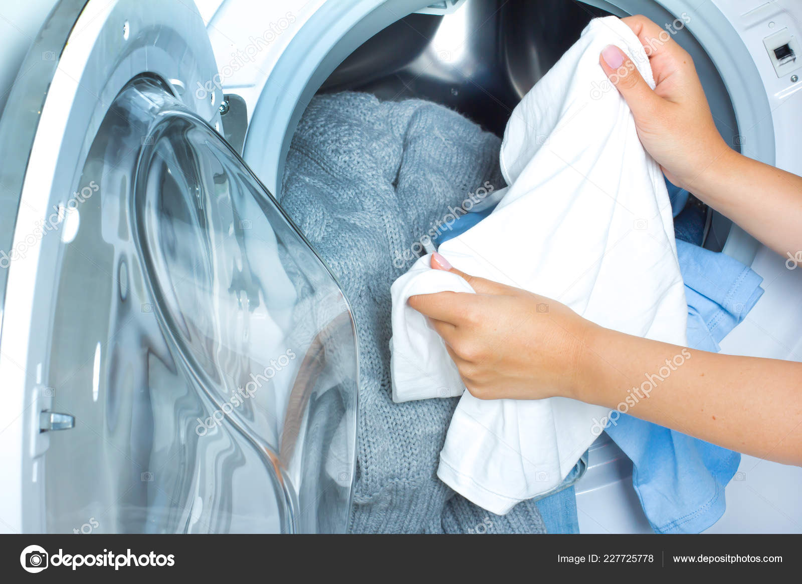 Preparing the wash cycle. Washing machine, hands and clothes Stock