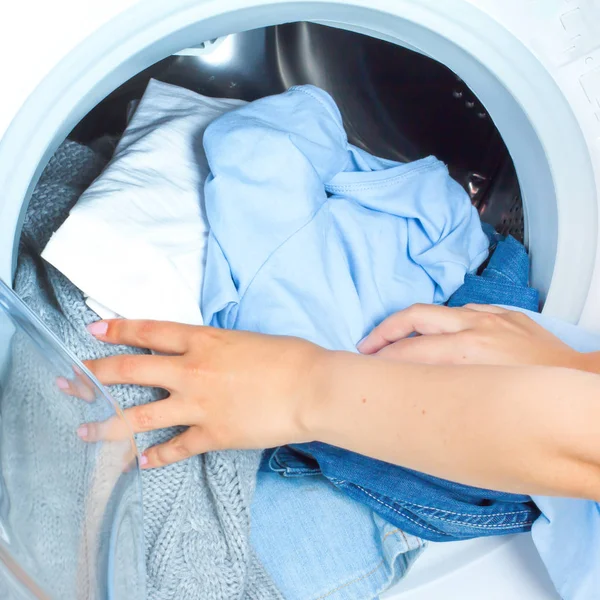 Vorbereitung des Waschzyklus. Waschmaschine, Hände und Kleidung Stockbild