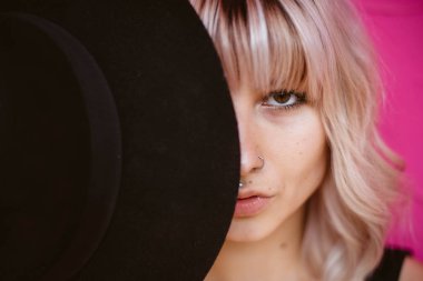 Güzel genç kadın dövme ve siyah şapka ile