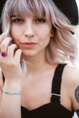 Güzel genç kadın dövme ve siyah elbise poz ile 