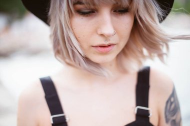 Güzel genç kadın dövme ve siyah elbise poz ile 