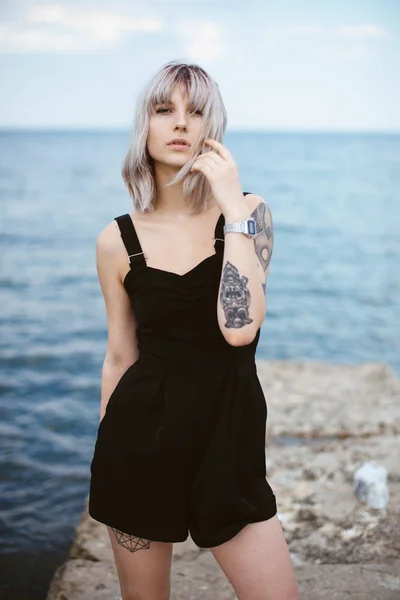 Όμορφη Νεαρή Γυναίκα Τατουάζ Και Μαύρο Φόρεμα Που Ποζάρει Στο — Φωτογραφία Αρχείου