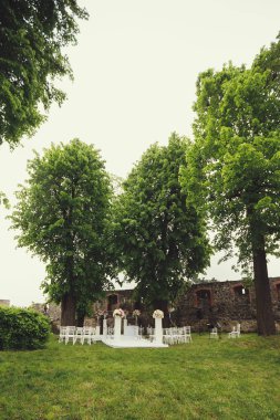 düğün kemer ve sandalyeler parkta yeşil çimenlerin üzerinde. Düğün töreni süslemeleri