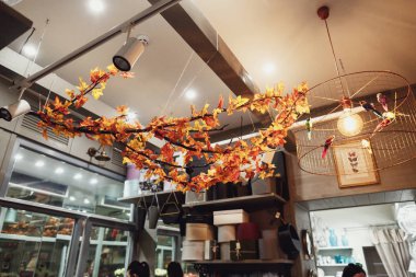 Güzel turuncu yaprak tavan odada ışık ile asılı.