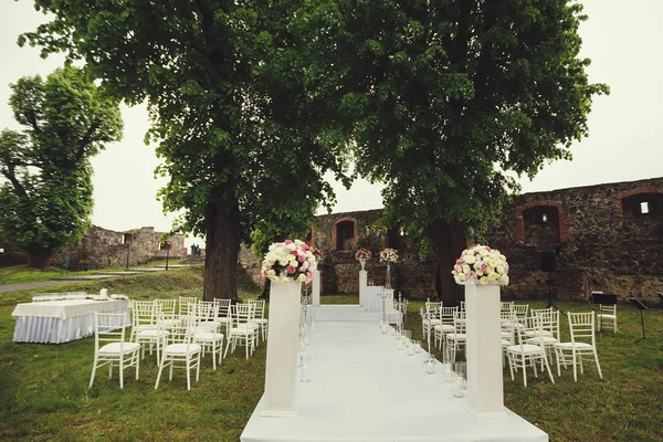 wedding arch and chairs on the green grass in the park.Wedding ceremony decorations