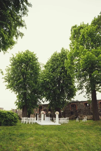 düğün kemer ve sandalyeler parkta yeşil çimenlerin üzerinde. Düğün töreni süslemeleri