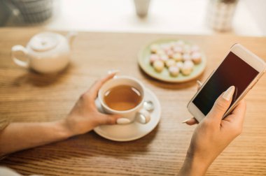 Genç güzel Bayan yürüdükten sonra kafede dinlenirken akıllı telefonda sohbet