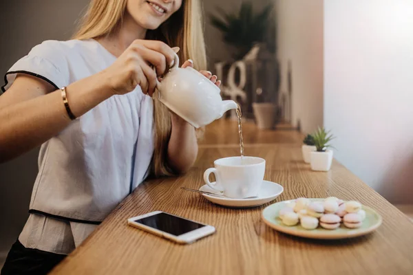 Mujer con teléfono y té caliente — Foto de Stock