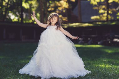  sevimli küçük neşeli kız açık havada sıcak ve güneşli yaz gününde beyaz elbiseli