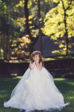  sevimli küçük neşeli kız açık havada sıcak ve güneşli yaz gününde beyaz elbiseli