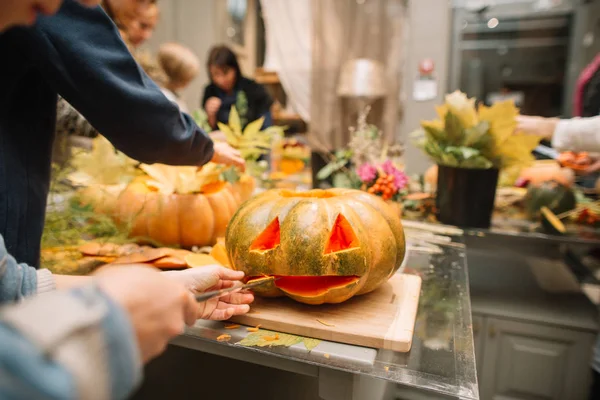 kids carving pumpkin lanterns for halloween - preparing the spooky accessories