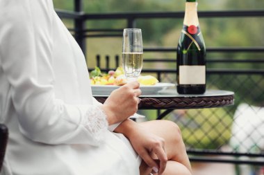  Gelin elinde bir kadeh şampanya tutuyor..