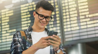  Yürüyüş ve cep telefonu üzerinde konuşurken gülümseyen seyahat adam