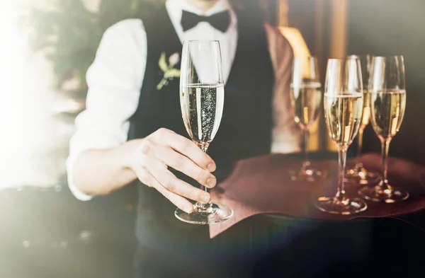 侍者在节日聚会或婚宴上拿着一碟香槟杯 — 图库照片