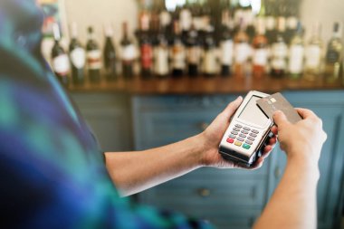 Müşteri eli NFC teknolojisiyle irtibatsız kredi kartıyla ödeme yapıyor..