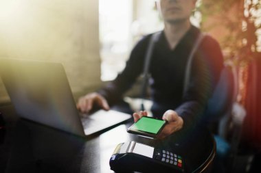 Mobil ödeme ile Nfc teknolojisi ya da kredi kartı terminal kullanan adam.