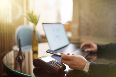 Mobil ödeme ile Nfc teknolojisi ya da kredi kartı terminal kullanan adam.