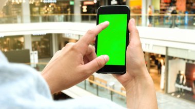 Adamın elleri açık havada hareket eden smartphone kullanarak. Adamın elleri metin mesajınız için boş kopya alanı ekranlı akıllı telefon tutarak atış görünümünü kırpılmış.