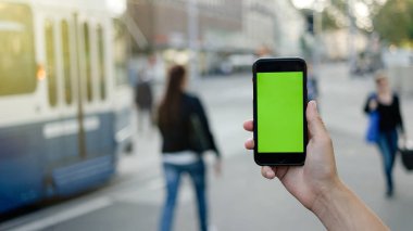 Adamın elleri açık havada hareket eden smartphone kullanarak. Adamın elleri metin mesajınız için boş kopya alanı ekranlı akıllı telefon tutarak atış görünümünü kırpılmış.