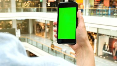 Adamın elleri açık havada hareket eden smartphone kullanarak. Adamın elleri metin mesajınız için boş kopya alanı ekranlı akıllı telefon tutarak atış görünümünü kırpılmış.