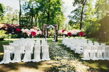 düğün kemer ve sandalyeler parkta yeşil çimenlerin üzerinde. Düğün töreni süslemeleri