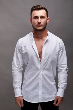 Gri arka plan üzerinde yakışıklı genç adam portresi. Kas modeli spor genç adam