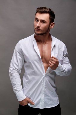 Gri arka plan üzerinde yakışıklı genç adam portresi. Kas modeli spor genç adam