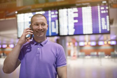 telefon havaalanında olan adam. Genç adam havaalanında smartphone kullanarak .