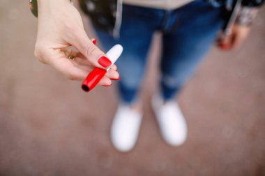 Elektronik Sigara elinde tutan kadın Close-up. Güzel kız elektronik sigara kullanır. Tütün sistem Iqos.