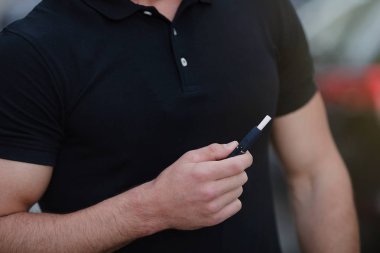 Elektronik Sigara içilmeyen bir sakal olan genç bir adam. Elektronik Sigara bir adamla Close-up. Tütün sistem Iqos.