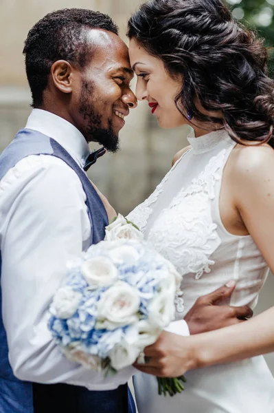 Wedding day. Stylish african groom and his pretty bride. African wedding couple emotional portrait loving bride and groom.