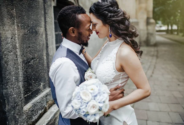 Wedding day. Stylish african groom and his pretty bride. African wedding couple emotional portrait loving bride and groom.