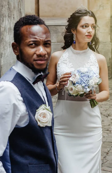 Wedding day. Stylish african groom and his pretty bride. African wedding couple emotional portrait loving bride and groom.