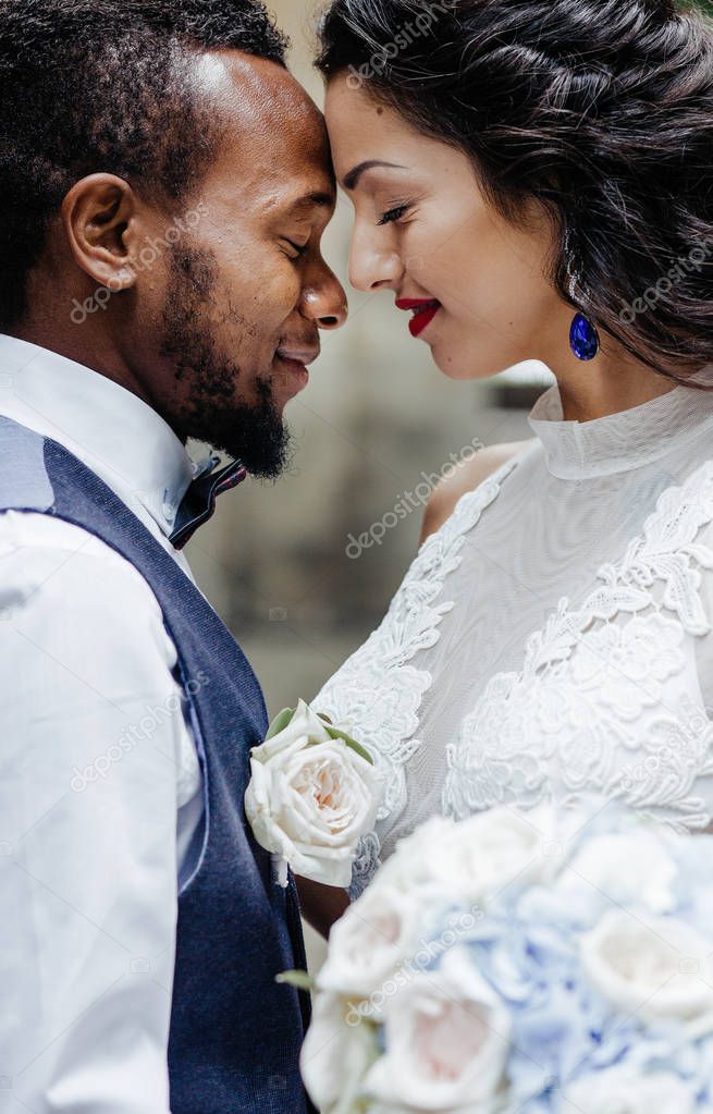 Wedding day. Stylish african groom and his pretty bride. African wedding couple emotional portrait loving bride and groom.